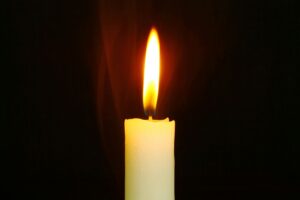 Customize Your Candle A single candle burning brightly in the dark, symbolizing light and hope.